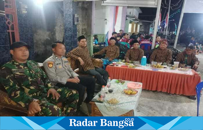 Petugas Polsek Tikung bersama warga melakukan pengamanan pagelaran wayang kulit dalam rangka tradisi sedekah bumi di Dusun Lenjer, Desa Dukuhagung, Kecamatan Tikung, Lamongan, Kamis (21/8/2025) malam. (Foto Dok Ho/RadarBangsa.co.id)