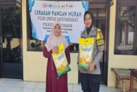 Warga dan anggota Polsek Tikung menunjukkan beras SPHP yang dijual dalam kegiatan Gerakan Pangan Murah di halaman Mako Polsek Tikung, Lamongan, Jumat (15/8/2025). (Foto Dok Ho/RadarBangsa.co.id)