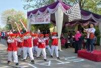 Ipda Andi Nurcahya melepas peserta lomba gerak jalan pelajar dari titik start di Lapangan Dusun Tikung, Desa Bakalanpule. (Foto Dok/RadarBangsa)