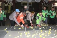 Driver ojek online bersama aparat kepolisian menyalakan lilin sebagai simbol doa dan solidaritas, mencerminkan kebersamaan dalam suasana penuh keakraban di Mapolres Probolinggo. (Foto Dok Ho/RadarBangsa.co.id)