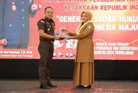 Wakil Wali Kota Probolinggo Ina Dwi Lestari menyerahkan plakat penghargaan kepada Kepala Kejaksaan Negeri Kota Probolinggo Dodik Hermawan pada Puncak Festival Literasi Hukum 2025 di Paseban Sena, Selasa (26/8/2025). (Foto: Diskominfo Kota Probolinggo)