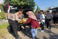 Kasat Samapta Polres Lamongan IPTU Yossy Eka Prasetya Suwanda menyerahkan beras SPHP kepada warga dalam kegiatan Gerakan Pangan Murah di Perum Graha Indah, Tambakrigadung, Sabtu (24/8/2025). (Foto Dok Ho/RadarBangsa.co.id)