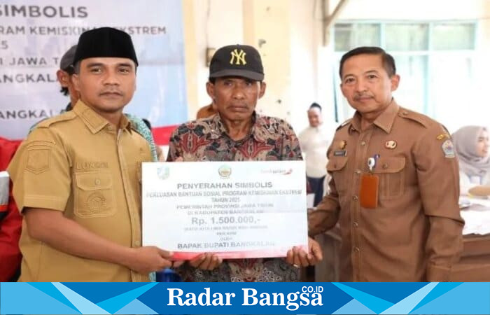 Bupati Bangkalan Lukman Hakim (kiri) menyerahkan secara simbolis bantuan sosial Program Penanggulangan Kemiskinan Ekstrem Tahun 2025 kepada salah satu penerima manfaat (tengah) di Kecamatan Geger, Senin (23/9/2025). (Foto Dok Ho/RadarBangsa.co.id)