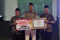 Bupati Pasuruan Rusdi Sutejo (kiri) menyerahkan hadiah kepada perwakilan Desa Purwodadi yang meraih Juara 1 Lomba Kampung Pancasila dalam rangka Hari Jadi ke-1096 Kabupaten Pasuruan. (RadarBangsa.co.id/Ho Kominfo Pasuruan) 