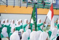 Kader Fatayat NU Lamongan mengibarkan bendera organisasi dan Merah Putih saat prosesi pelantikan Pimpinan Cabang Fatayat NU Lamongan masa khidmat 2025–2030 di Lamongan Sport Center, Jumat (5/9/2025). (Foto Dok Ho/RadarBangsa.co.id)