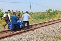 Petugas bersama warga mengevakuasi jasad korban tertabrak kereta api di jalur rel kawasan Desa Plosowahyu, Kecamatan Lamongan, Senin (1/9/2025). (DoK Foto RadarBangsa.co.id)