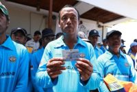 Seorang nelayan Blimbingsari menunjukkan kartu e-Pas Kecil yang baru diterimanya dalam layanan jemput bola yang digelar Pemkab Banyuwangi bersama KSOP Tanjungwangi, Kamis (4/9/2025). (Foto Dok Ho/RadarBangsa.co.id)