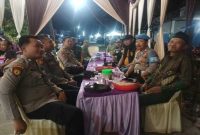 Sejumlah aparat kepolisian, TNI, dan Satpol PP duduk bersama dalam suasana santai saat melaksanakan pengamanan hajatan khitan dengan hiburan musik elektune di Dusun Gabus, Desa Wonokromo, Kecamatan Tikung, Lamongan, Kamis (25/9/2025) malam. ( Foto Dok Ho/RadarBangsa.co.id)