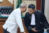 Drs. Moch. Wahyudi mengenakan baju putih terlihat berbicara bisik-bisik dengan kuasa hukumnya, Muhammad Ridlwan, SH, (Foto Dok Ho/RadarBangsa.co.id)