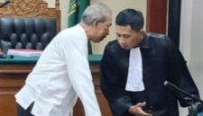 Drs. Moch. Wahyudi mengenakan baju putih terlihat berbicara bisik-bisik dengan kuasa hukumnya, Muhammad Ridlwan, SH, (Foto Dok Ho/RadarBangsa.co.id)