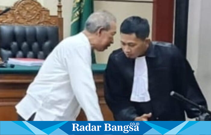Drs. Moch. Wahyudi mengenakan baju putih terlihat berbicara bisik-bisik dengan kuasa hukumnya, Muhammad Ridlwan, SH, (Foto Dok Ho/RadarBangsa.co.id)
