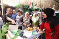 Wakil Bupati Malang, Dra. Hj. Lathifah Shohib, berinteraksi dengan pedagang saat membuka Pasar Rakyat Terongdowo Tempo Doeloe di Desa Tirtomoyo, Kecamatan Pakis, Kamis (5/9) petang. (Dok Foto Prokopim)