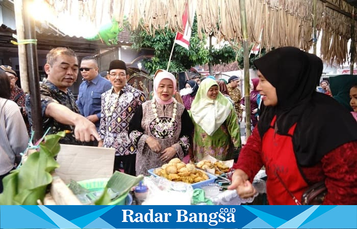 Wakil Bupati Malang, Dra. Hj. Lathifah Shohib, berinteraksi dengan pedagang saat membuka Pasar Rakyat Terongdowo Tempo Doeloe di Desa Tirtomoyo, Kecamatan Pakis, Kamis (5/9) petang. (Dok Foto Prokopim)