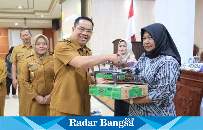 Wali Kota Probolinggo dr. H. Mochammad Aminuddin menyerahkan bantuan peralatan produksi kepada pelaku UMKM kuliner berbasis olahan mi saat kegiatan bimbingan teknis di Puri Manggala Bhakti, Selasa (9/9/2025). (Foto Dok Ho/RadarBangsa.co.id)