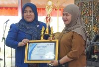 Wartawan Kompas.com, Yulian Isna Sri Astuti (kiri), menerima piala dan piagam penghargaan sebagai juara pertama lomba news writing Diskominfo Merdeka Fest 2025 di Bangkalan, Rabu (24/9/2025). (Foto Dok Ho/RadarBangsa.co.id)