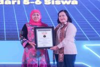 Gubernur Khofifah Indar Parawansa menerima Piagam Penghargaan MURI atas keberhasilan Program SMA Double Track mencetak 1.600 Kelompok Usaha Siswa di Jawa Timur, Rabu (8/10/2025). (Foto Dok Ho/RadarBangsa.co.id)