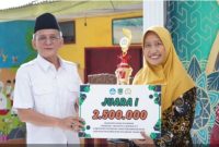Wakil Bupati Pasuruan, KH Shobih Asrori (kiri), menyerahkan piala dan hadiah kepada pemenang pertama Festival Pendidikan Agama Islam (PAI) 2025 di SDN Ngadimulyo, Kecamatan Sukorejo, Rabu (15/10/2025). (Foto Dok Ho/RadarBangsa.co.id)