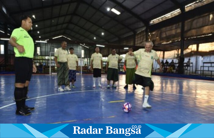 Wakil Bupati Pasuruan, Shobih Asrori, menendang bola pertama sebagai tanda dimulainya turnamen Futsal Sarungan dalam rangka Hari Santri Nasional 2025 di Lapangan Futsal King, Warungdowo, Kecamatan Pohjentrek, Sabtu (18/10/2025). (Foto Dok Ho/RadarBangsa.co.id)