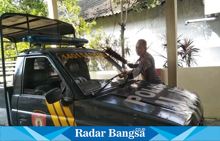 Anggota Polsek Tikung Polres Lamongan membersihkan mobil patroli di halaman Mapolsek, Rabu (15/10/2025). (Foto Dok Ho/RadarBangsa.co.id)