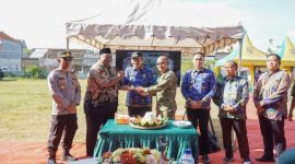 Bupati Lamongan Yuhronur Efendi menyerahkan piala simbolis usai peletakan batu pertama pembangunan Koperasi Desa Kelurahan Merah Putih (KDMP) Sidorejo, Kecamatan Deket, Jumat (17/10/2025). (Foto Dok Ho/RadarBangsa.co.id)