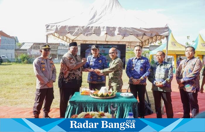 Bupati Lamongan Yuhronur Efendi menyerahkan piala simbolis usai peletakan batu pertama pembangunan Koperasi Desa Kelurahan Merah Putih (KDMP) Sidorejo, Kecamatan Deket, Jumat (17/10/2025). (Foto Dok Ho/RadarBangsa.co.id)
