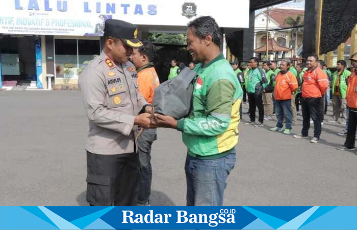 Kapolres Lamongan AKBP Agus Dwi Suryanto menyerahkan sarana kontak kepada perwakilan driver ojek online saat Apel Ojol di Mapolres Lamongan, Jumat (24/10/2025). (Foto Dok Ho/RadarBangsa.co.id)