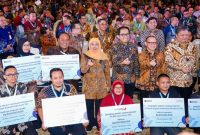 Gubernur Jawa Timur Khofifah Indar Parawansa bersama sejumlah menteri dan perwakilan debitur saat menghadiri acara Akad Massal KUR Nasional di Dyandra Convention Center, Surabaya, Selasa (21/10/2025). (Foto Dok Ho/RadarBangsa.co.id)
