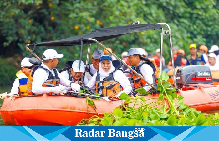 Gubernur Jawa Timur Khofifah Indar Parawansa bersama prajurit Korps Marinir TNI AL melakukan aksi bersih-bersih di Kali Surabaya dalam rangka HUT ke-80 Provinsi Jatim dan World Clean Up Day 2025, Minggu (19/10/2025). (Foto Dok Ho/RadarBangsa.co.id)