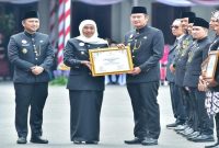 Gubernur Jatim Khofifah Indar Parawansa menyerahkan penghargaan Penamaan Rupabumi 2025 kepada Bupati Lamongan Yuhronur Efendi di Gedung Negara Grahadi, Surabaya. (Foto Dok Ho/RadarBangsa.co.id)