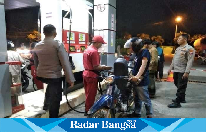 Aiptu I Ketut GB bersama anggota Polsek Tikung lainnya memantau langsung aktivitas pengisian BBM di SPBU Tikung, Lamongan, Senin (27/10/2025), untuk memastikan situasi aman dan kondusif pasca ramainya laporan motor mogok. (Foto Dok Ho/RadarBangsa.co.id)