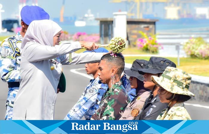 Gubernur Jawa Timur Khofifah Indar Parawansa menyiramkan air kembang kepada taruna dalam prosesi Pembaretan Kolektif SMA Negeri Taruna se-Jawa Timur di Dermaga Madura, Koarmada II TNI AL Surabaya, Kamis (16/10/2025).  (Foto Dok Ho/RadarBangsa.co.id)