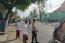 Petugas Polsek Tikung bersama warga mengatur arus lalu lintas di depan Kantor MWC NU Tikung, Lamongan, saat pelaksanaan Apel Hari Santri Nasional 2025, Rabu (22/10/2025) pagi. (Foto Dok Ho/RadarBangsa.co.id)