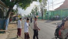 Petugas Polsek Tikung bersama warga mengatur arus lalu lintas di depan Kantor MWC NU Tikung, Lamongan, saat pelaksanaan Apel Hari Santri Nasional 2025, Rabu (22/10/2025) pagi. (Foto Dok Ho/RadarBangsa.co.id)