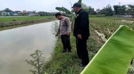 Anggota Polsek Tikung meninjau kondisi saluran irigasi di wilayah rawan banjir Kecamatan Tikung, Lamongan, saat pelaksanaan Patroli Kota Presisi, Minggu (5/10) (Foto Dok Ho/RadarBangsa.co.id)