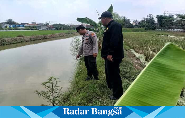 Anggota Polsek Tikung meninjau kondisi saluran irigasi di wilayah rawan banjir Kecamatan Tikung, Lamongan, saat pelaksanaan Patroli Kota Presisi, Minggu (5/10) (Foto Dok Ho/RadarBangsa.co.id)