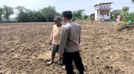 Anggota Polsek Tikung berbincang dengan warga saat patroli di area program Pekarangan Pangan Bergizi (P2B) di Desa Botoputih, Kecamatan Tikung, Kabupaten Lamongan, Minggu (5/10/2025).
