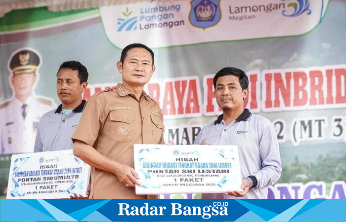 Bupati Lamongan Yuhronur Efendi menyerahkan bantuan sarana pertanian kepada perwakilan petani saat kegiatan Panen Raya Padi Masa Tanam III di Desa Sidomukti, Kecamatan Kembangbahu, Lamongan, Senin (27/10/2025). (Foto Dok Ho/RadarBangsa.co.id)