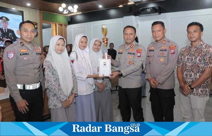 Kapolres Lamongan AKBP Agus Dwi Suryanto menyerahkan piala kepada pemenang Lomba Cerdas Cermat Kamtibmas di Polres Lamongan, Jumat (17/10/2025). (Foto Dok Ho/RadarBangsa.co.id)