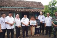 Bupati Malang Drs. HM Sanusi, MM (tengah) menyerahkan secara simbolis bantuan program Bedah Rumah kepada warga Dusun Sido Makmur, Desa Brongkal, Kecamatan Pagelaran, Rabu (5/11) siang (Foto Dok Ho/RadarBangsa.co.id)