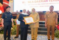 Gubernur Jawa Timur Khofifah Indar Parawansa menyerahkan penghargaan kepada Bupati Banyuwangi, Ipuk Fiestiandani, dalam Rakor Forkopimda 2025 di Surabaya (Foto Dok Ho/RadarBangsa.co.id)