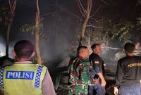 Petugas Polsek Ngimbang  dan TNI bersama Damkar Kecamatan Ngimbang berjibaku memadamkan api yang membakar kandang ayam di Desa Lawak, Lamongan, Jumat malam (31/10). (Foto Dok Ho/RadarBangsa.co.id)