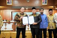 Bupati Pasuruan Rusdi Sutejo menerima aset rampasan negara senilai Rp1,3 miliar dari Direktur Labuksi KPK Mungki Hadipratikto di Aceh. Penyerahan ini disaksikan jajaran Pemkab Pasuruan. (Foto: Dok. Ho/RadarBangsa.co.id) 
