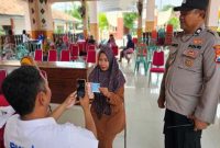 Petugas Polsek Tikung mengawasi proses penyaluran PKH Lansia Jatim bagi 89 penerima di Pendopo Kecamatan Tikung, Jumat (21/11/2025). (Foto Dok Ho/RadarBangsa.co.id)