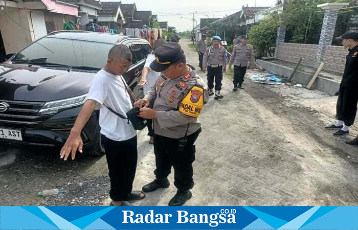 Kapolsek Tikung memeriksa tas dan barang bawaan rombongan IKSPI Ranting Tikung yang berangkat mengikuti pengesahan warga baru di Madiun, Kamis (27/11/2025). Foto Dok Ho/RadarBangsa.co.id 