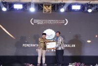 Kepala Diskominfo Bangkalan menerima penghargaan Badan Publik Menuju Informatif pada KI Awards 2025. (Foto Dok Ho/RadarBangsa.co.id)