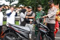Tri Agus Purnama memeluk istrinya setelah diumumkan sebagai pemenang sepeda motor Undian Sipundiwangi tahap II saat CFD di Banyuwangi, Minggu (14/12/2025). Foto Dok Ho/RadarBangsa.co.id