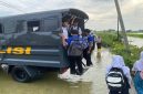 Petugas Satsamapta Polres Lamongan mengantar pelajar di wilayah banjir Kalitengah, Lamongan, Kamis (30/1/2026). (Foto Dok Ho/Nul-RadarBangsa.co.id)
