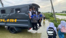 Petugas Satsamapta Polres Lamongan mengantar pelajar di wilayah banjir Kalitengah, Lamongan, Kamis (30/1/2026). (Foto Dok Ho/Nul-RadarBangsa.co.id)