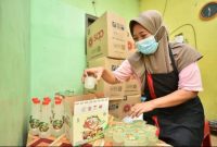 Wiji Astuti menata ribuan kardus sari matoa siap distribusi menjelang Hari Raya Idul Fitri. (Foto Dok Ho/RadarBangsa.co.id)