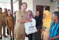 Bupati Lamongan Yuhronur Efendi menyerahkan bantuan pada bakti sosial PWI Lamongan di Desa Kedungkumpul, Senin (9/2/2026). (Foto Dok Ho/RadarBangsa.co.id)